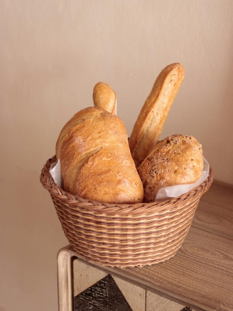 A rustic basket with artisanal bread on a wooden table, perfect for bakery promotions.