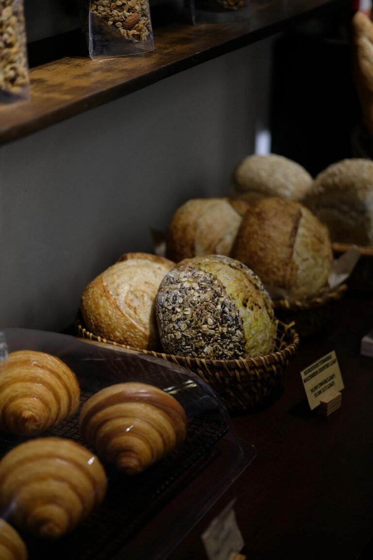 A variety of fresh breads and croissants beautifully arranged in a cozy bakery setting.