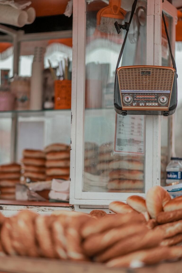 Close-up of vintage radio hanging in bakery, surrounded by fresh bread.