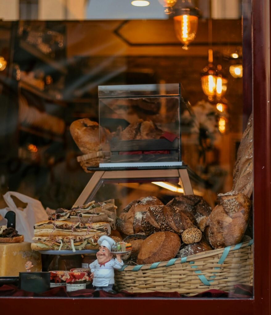 Delightful window display featuring fresh breads and pastries in a cozy bakery setting.